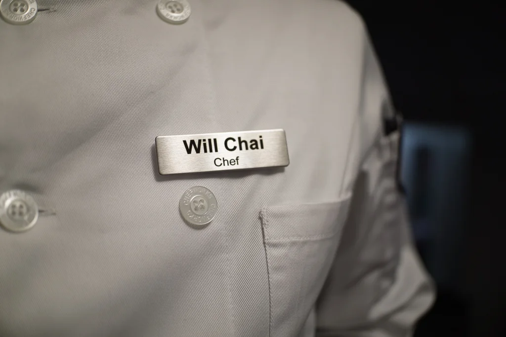 Will Chai’s chef badge on a white chef jacket