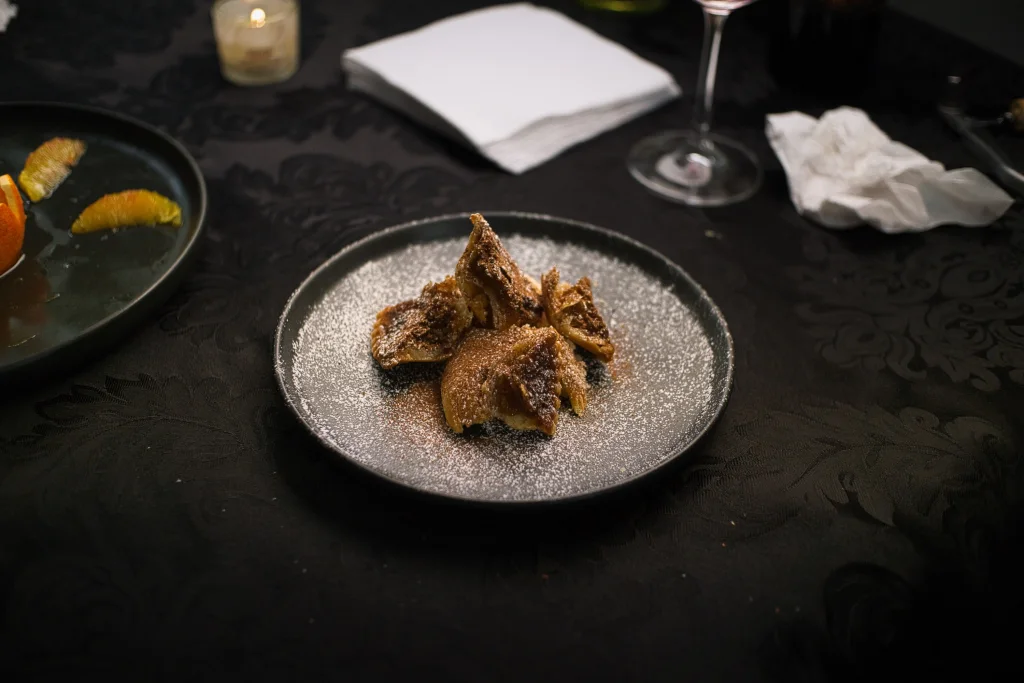 Dessert set among a candle, a wine glass, and folded napkins