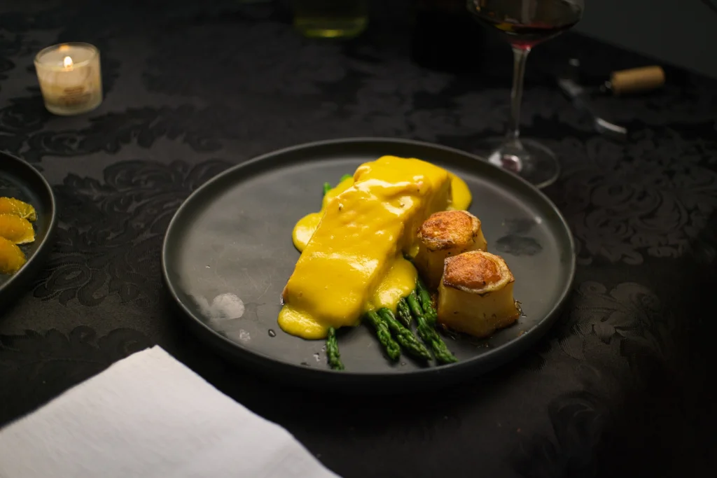 Salmon with asparagus set among wine glasses and folded napkins