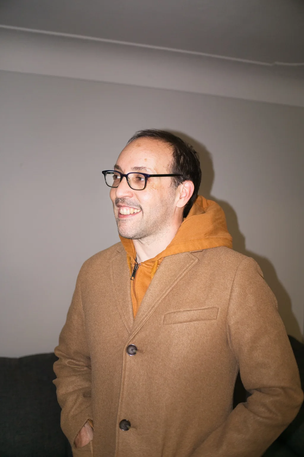 Felipe Hoffa smiling in a camel coat and orange hood after dinner